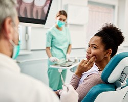 Patient with toothache looking at dentist in treatment chair