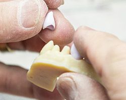 Technician crafting a dental crown restoration
