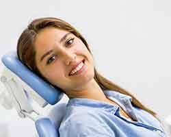Woman sitting back in dental chair smiling
