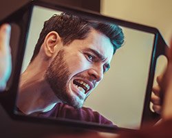 Man looking at smile in mirror