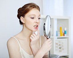 Woman looking at her smille in the mirror