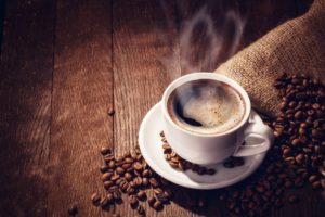 Steaming mug of hot coffee on a wooden table