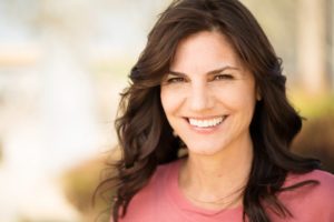 Woman with dental implants smiling outside