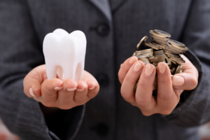 Dentist in Highland Park holding tooth and money.