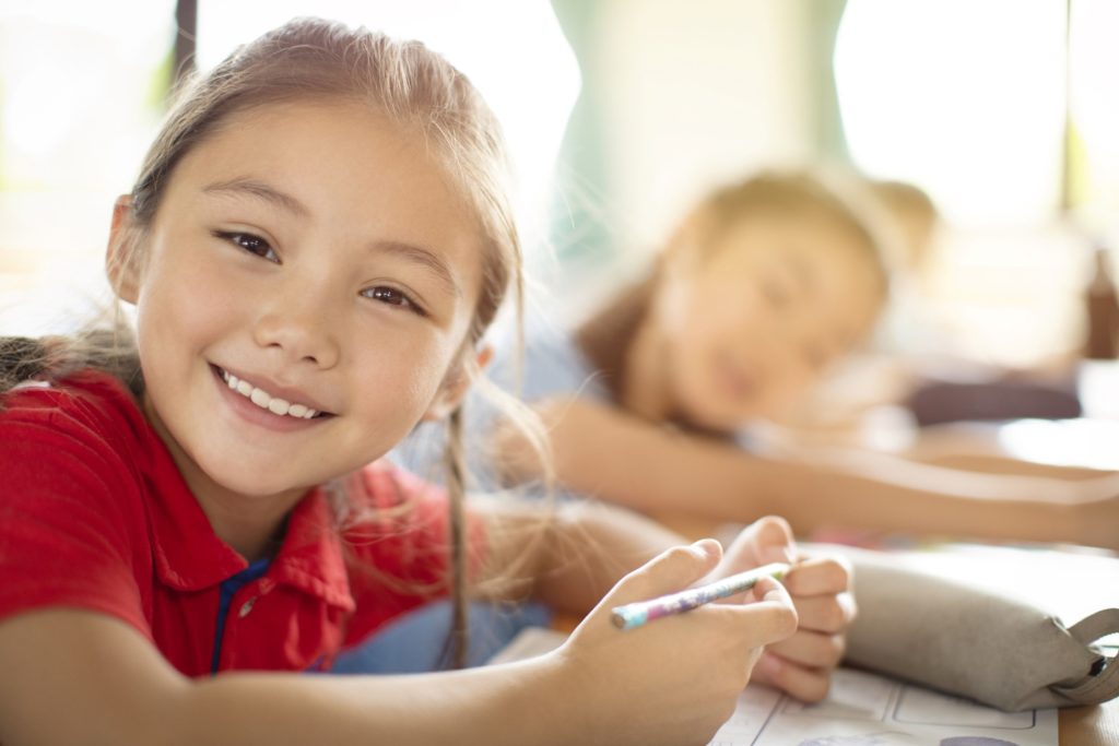 Closeup of child smiling in classroom