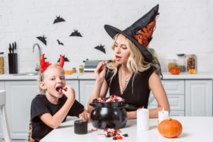 adult eating Halloween candy with child
