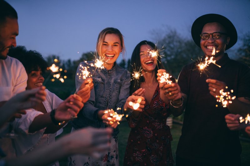 friends holding sparklers and smiling