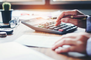 Hands using calculator to do taxes