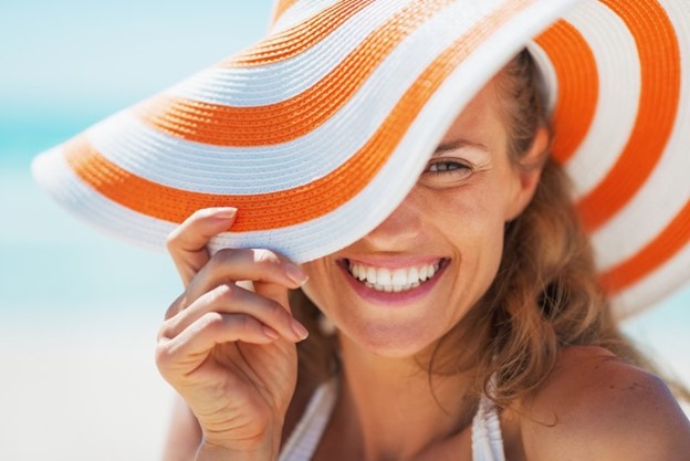 Smiling woman with beach hat.