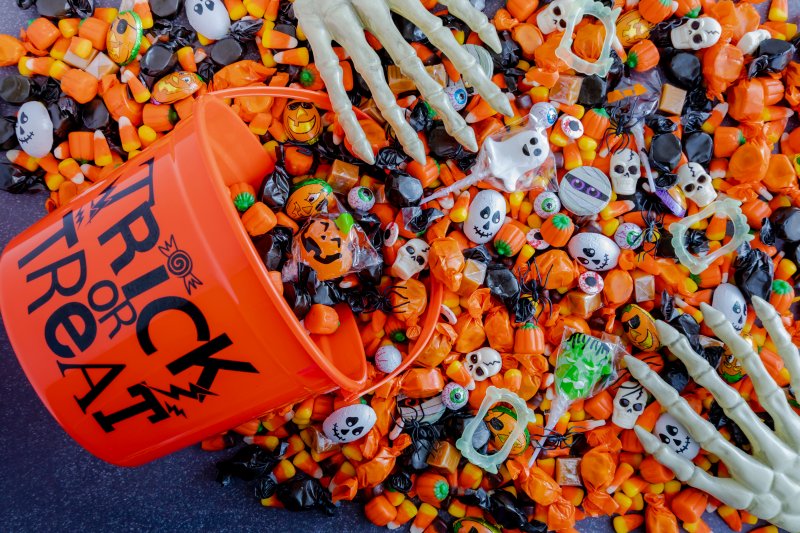 Halloween candy spilling out of orange trick or treat bucket