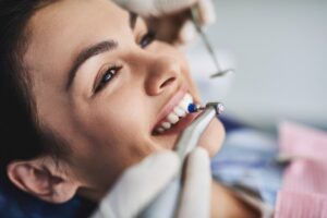 Young woman having her teeth cleaned by dentist.