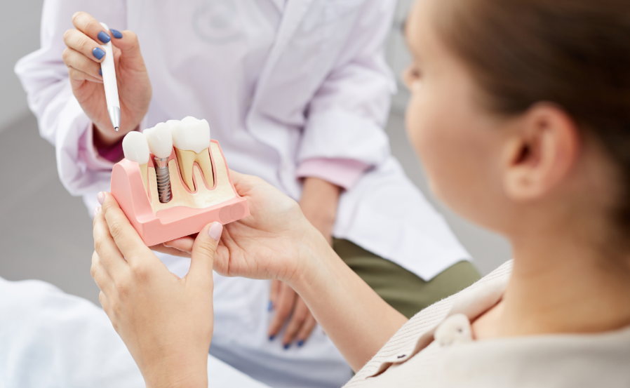 Dentist showing patient model dental implant